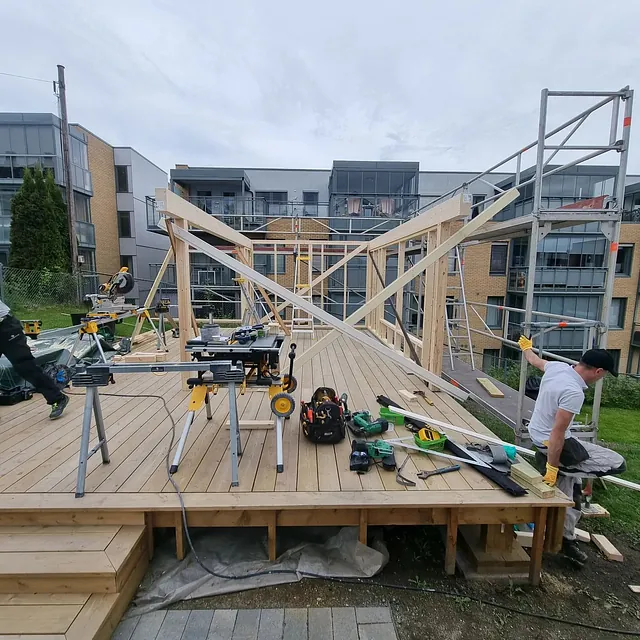 Terrassekonstruksjon med verktøy og arbeidere.